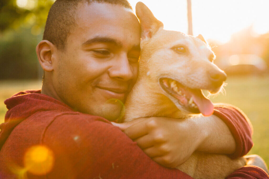 man hugging dog