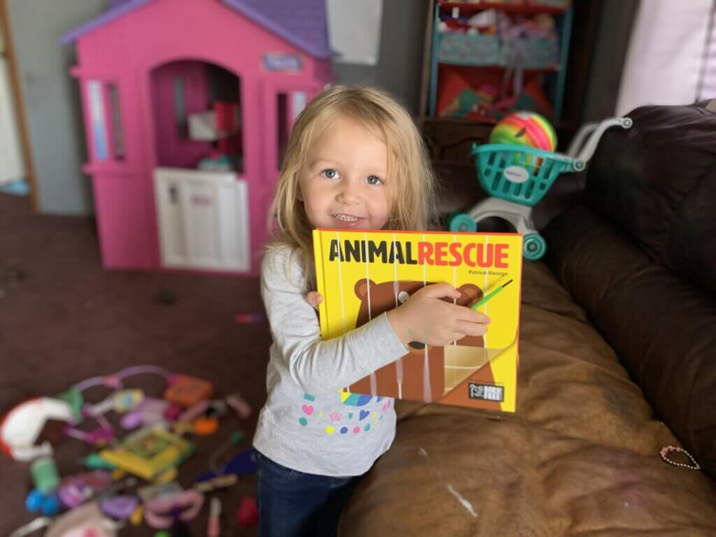 Nina con libro de rescate animal 